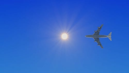 Bright Sun in Clear Blue Sky with Aircraft Silhouette on the Edge