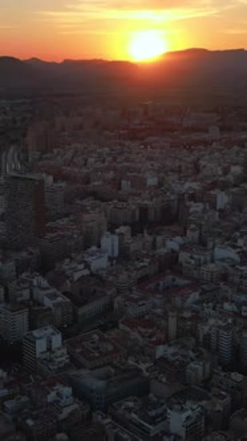 Aerial drone view of the buildings in Alicante, Spain at sunset. Vertical