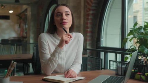 Smiling Young Woman Thinking in Modern Office
