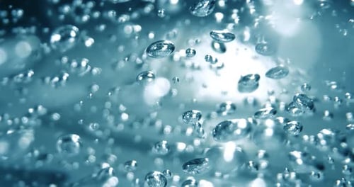 Many water bubbles in blue water close up, abstract water wave with bubbles in slow motion.