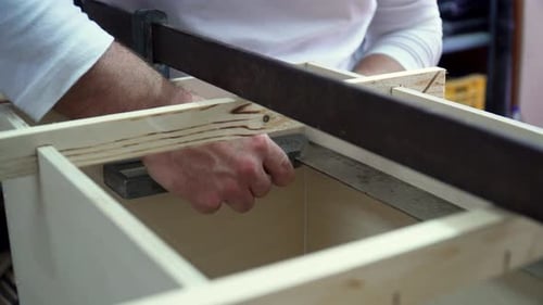 Close up on hands of professional artisan measuring wood with metal ruler tools