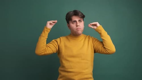 Upset Man Making Blah Blah Gesture in Green Studio