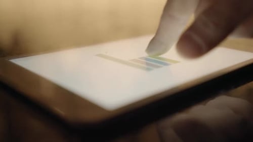 Finger Reviews Charts and Graphs on Tablet