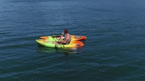 Couple kayaking on lake enjoying a summer adventure drone view