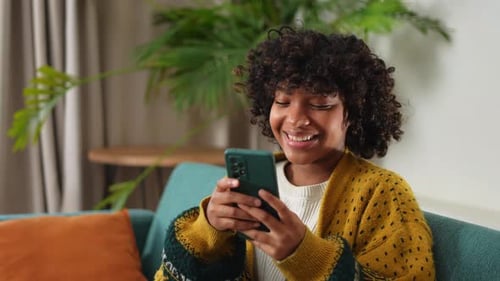 Woman Using Smartphone on Couch at Home