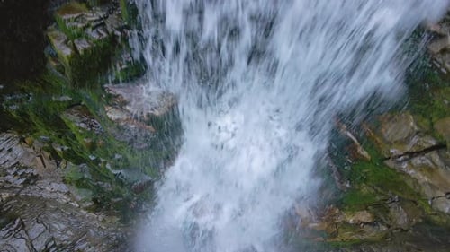 Waterfall on Mountain River with White Foamy Water Falling Down From Rocky Formation in Summer