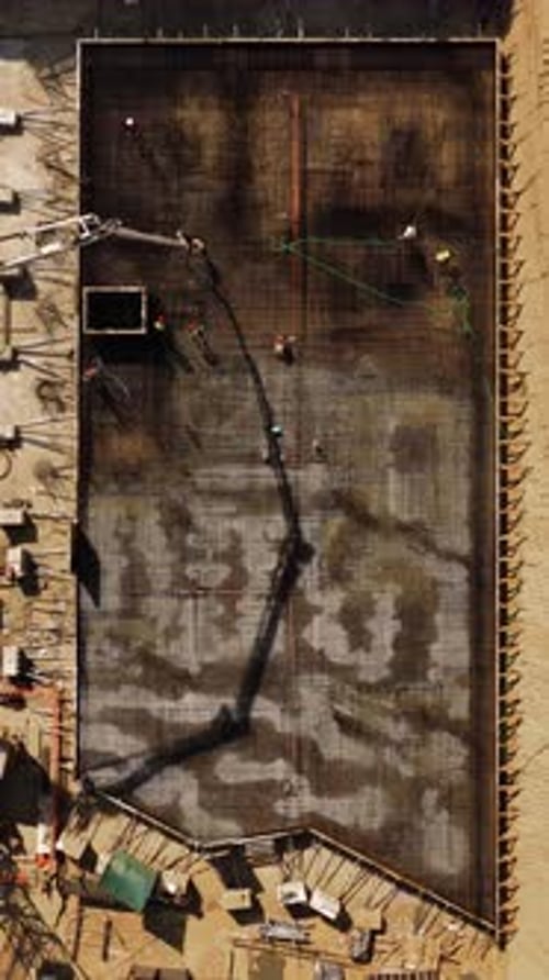 Workers Pour Concrete Foundation from Above