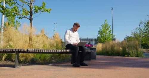 Mann arbeitet am Computer im Park