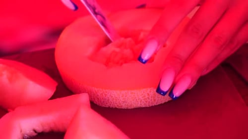 In kleine Stücke geschnittene Melone Frau Melone schneiden Die helle Küche am Morgen Desserts im Sommer