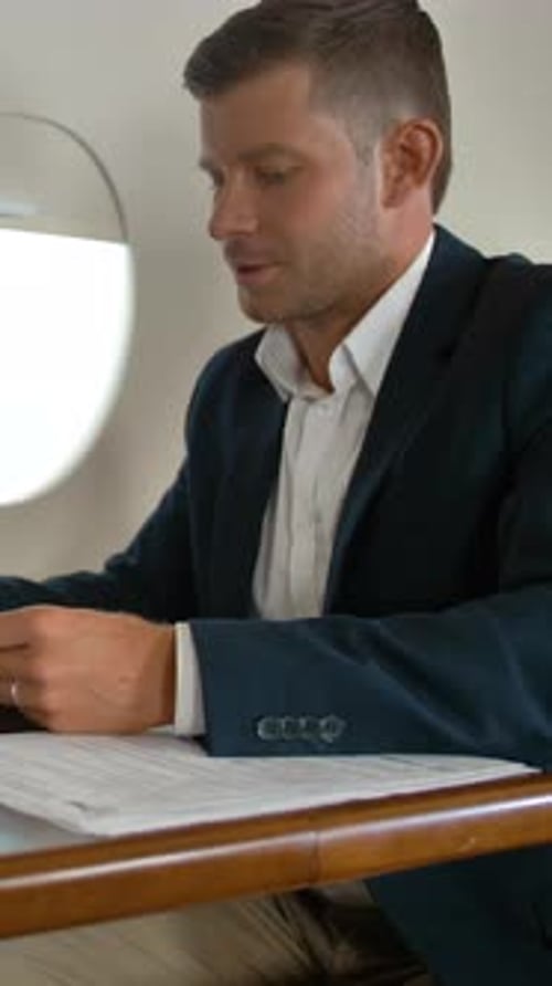 Man Reviews Documents on Private Jet Flight