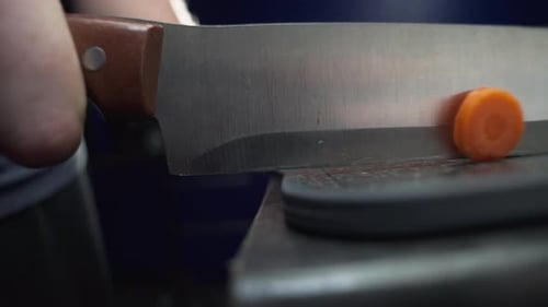 Slicing Carrots with Knife on Cutting Board