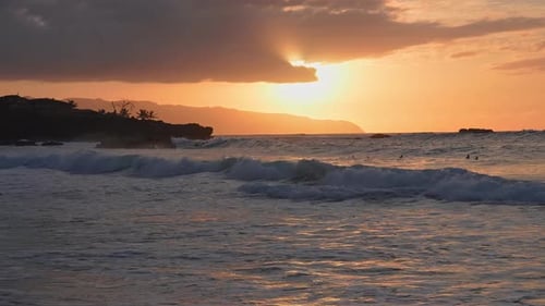 Sonnenuntergang über Hawaiian Beach mit Wellen und Schwimmern in Bewegung