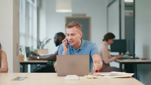 Angry business man yelling on mobile phone at coworking space