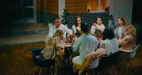 Friends Enjoying Outdoor Dinner Party at Night