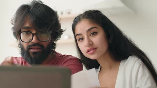Indian Arabian Family Couple Woman Man Use Laptop Read Bank Document Calculating Loan Debt Taxes
