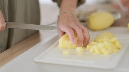 Woman Cutting Potatoes on the Board Cooking Vegetables Dinner in Kitchen Close Up of Females Hands