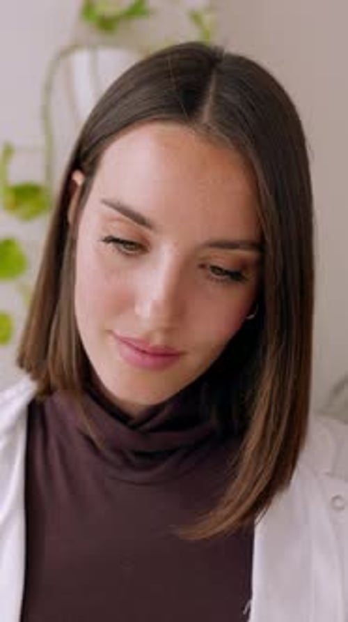 Young Female Doctor Using Laptop Sitting on Desk at Medical Consultation