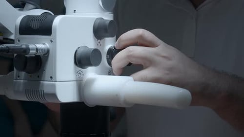 Researcher working with a microscope, close up