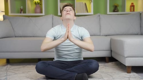 Young Man Practicing Yoga and Meditation at Home