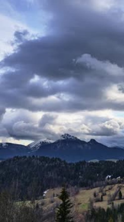Vertical Timelapse of Dramatic Storm Clouds Moving Over Snowy Mountain Peaks