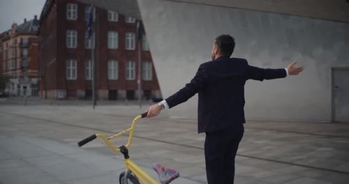 Businessman on BMX Bike Performs Acrobatic Stunt