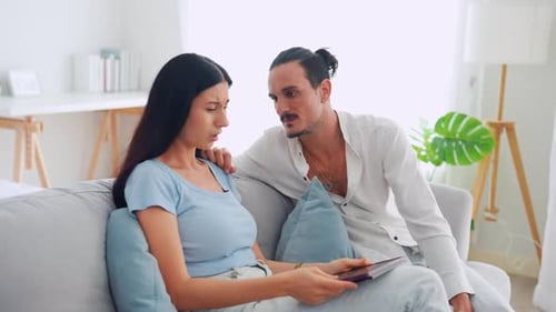 Man Comforts Upset Woman on Sofa at Home
