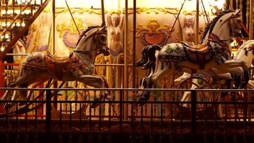 Horses inside moving Carousel, roundabout or merry-go-round surround with colorful lights