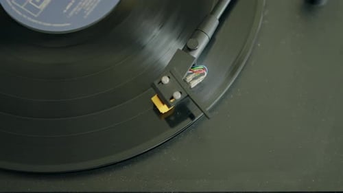 Close-up of a vinyl record playing on a turntable, highlighting the retro audio equipment in action.