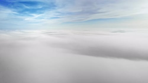 Aerial view from a drone flying above the lush clouds reflecting the sunlight