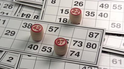 Close-Up of Bingo Cards and Wooden Number Barrels