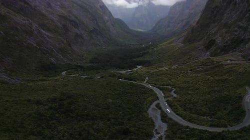 Estrada sinuosa passando por montanhas, neblina e nuvens em Milford Sound, Nova Zelândia, no sul I