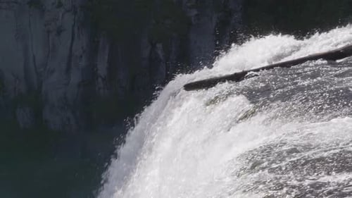 Top view of a large waterfall is seen flowing down a cliff.
