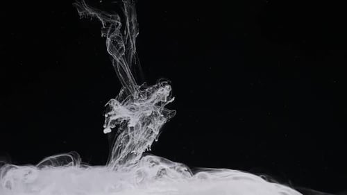 White Ink Flowing in Water on Black Background