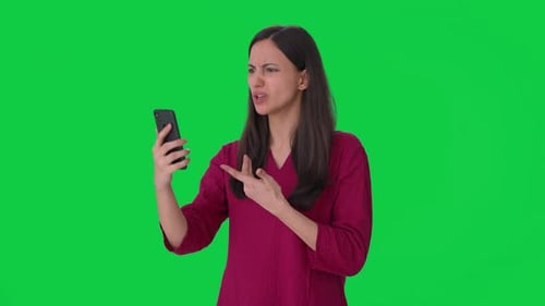 Angry Indian woman shouting on someone on video call Green screen