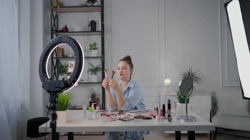 Mujer bloguera de belleza filmando una reseña sobre pinceles cosméticos en Home Studio Stream Influencer of Beauty