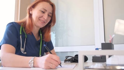 Woman Doctor Writing Medicine Order for Patient in Clinic