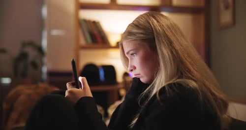Night, phone and sad woman with depression, anxiety and stress on social media on sofa in home