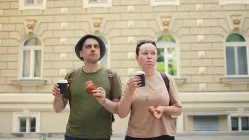 Couple Walking, Eating Pastries in the City