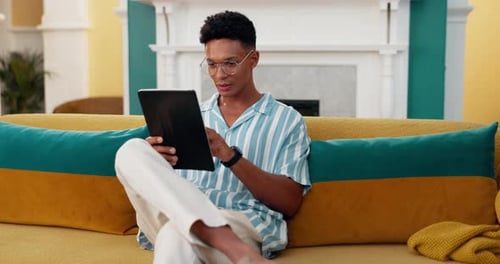Scroll, success and tablet with man on sofa for online reading, good news and social media post