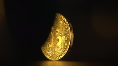 Eine glänzende Bitcoin-Münze auf dunklem Hintergrund, die moderne Finanzen und Wohlstand symbolisiert