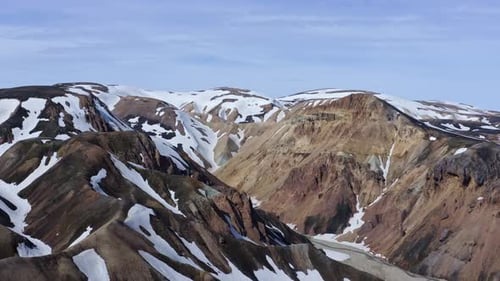 Descending aerial drone view focusing on the Brandsgil valley in Landmannalaugar, Iceland.