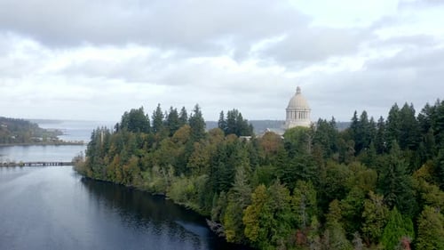 Aerial flying over state capital in Olympia WA overlooking the city with views of the mountain and l