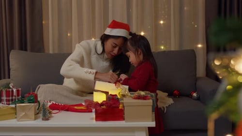 Mother and Child Opening Christmas Gifts Together at Home