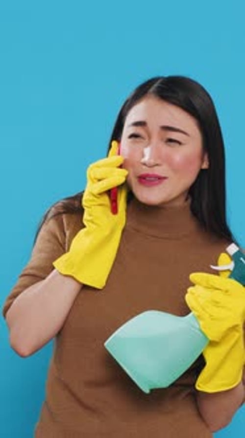 Woman in Gloves Talking on Phone with Cleaner