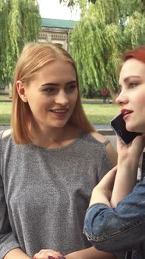 Two Girls Sharing a Joyful Phone Conversation