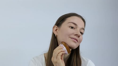 Young Woman Applying Makeup with Brush