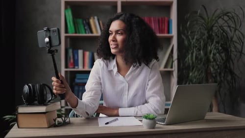 Woman at Desk Vlogging with Phone and Tripod