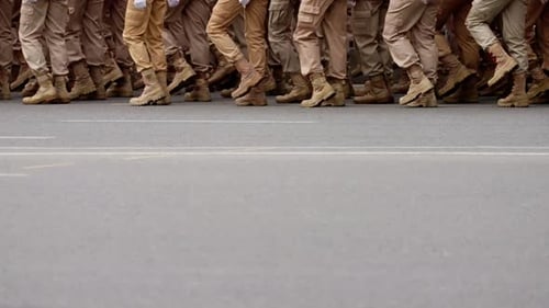 Closeup of Uniformed Soldiers Marching in Synchronized Formation Along an Urban Street Showcasing