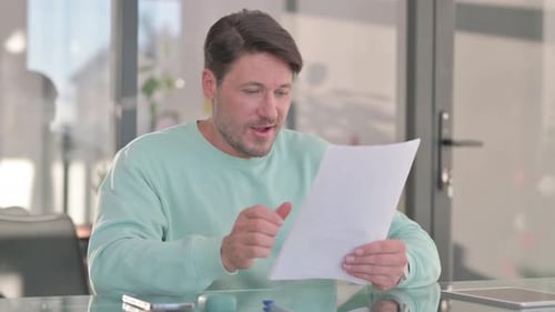 Man Reads Good News in an Office Setting