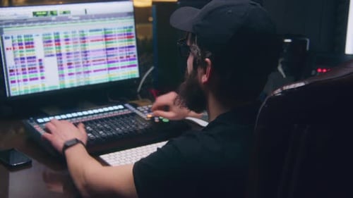 Audio Engineer Uses DAW Controller in Sound Recording Studio